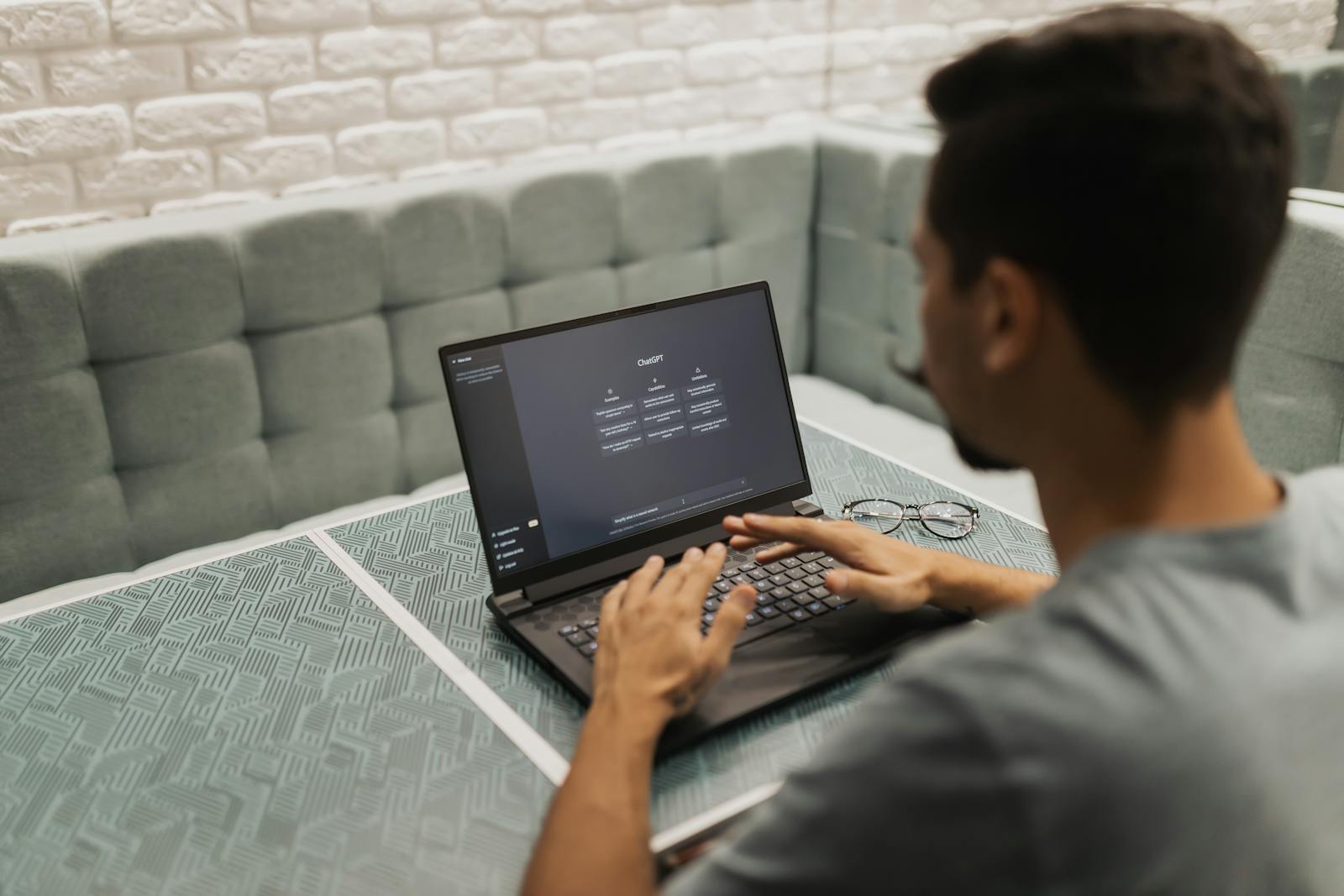 A man is sitting at a table with a laptop